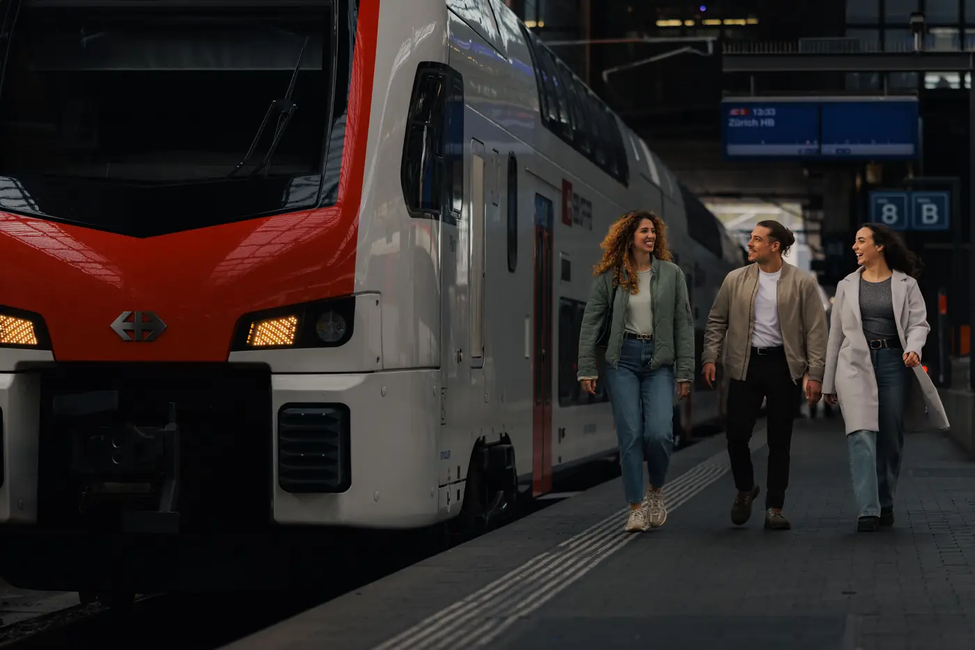 Travellers walking past a Swiss train on the platform